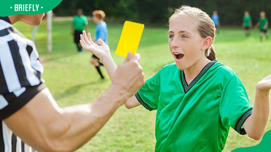 Female teenage soccer player getting a yellow card Female teenage soccer player getting a yellow card
